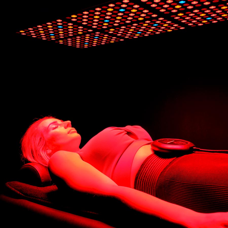 Laying under CELLER8 red light wearing CELLER8 around waist