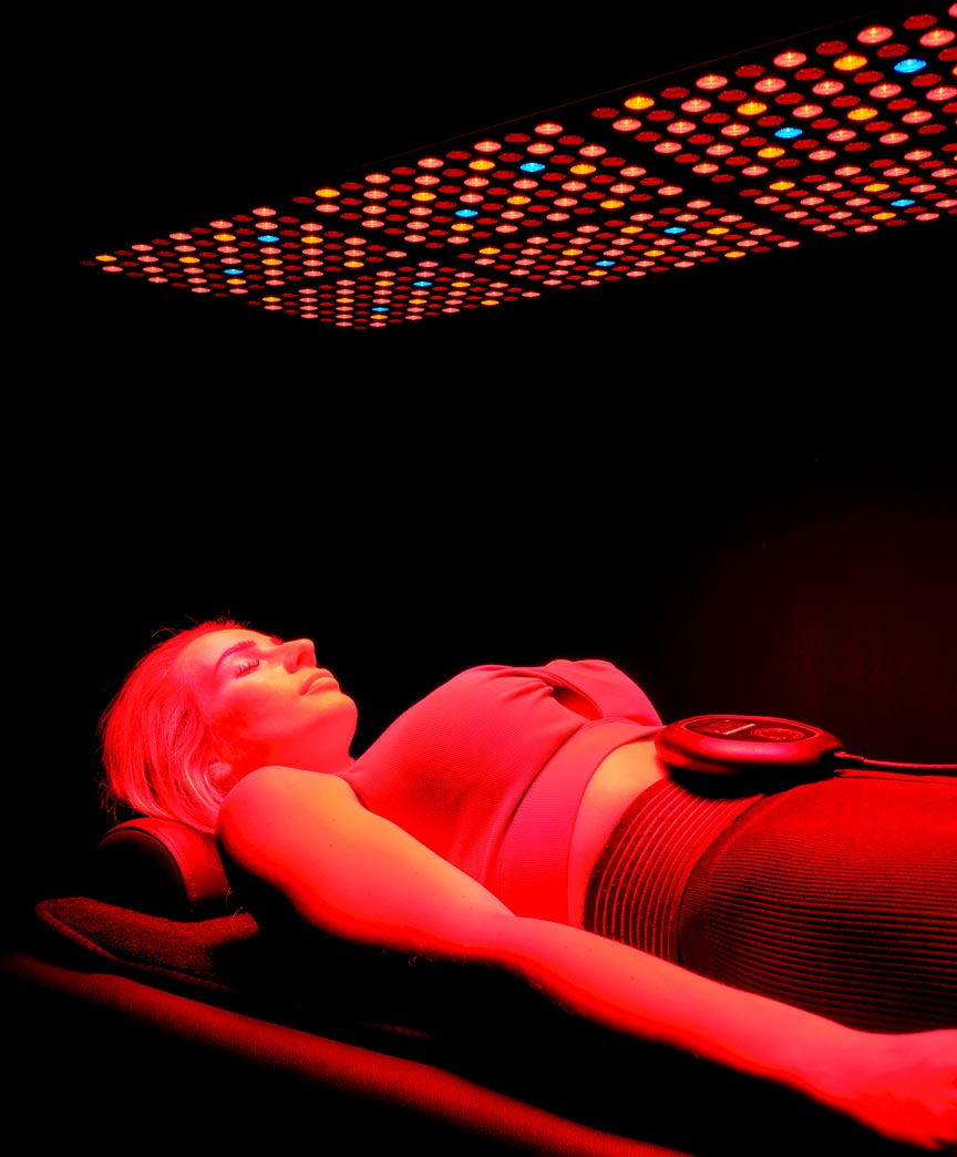 Laying under CELLER8 red light wearing CELLER8 around waist