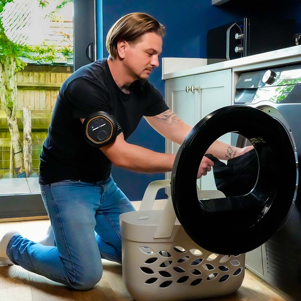 Man putting washing in machine wearing CELLER8 on arm