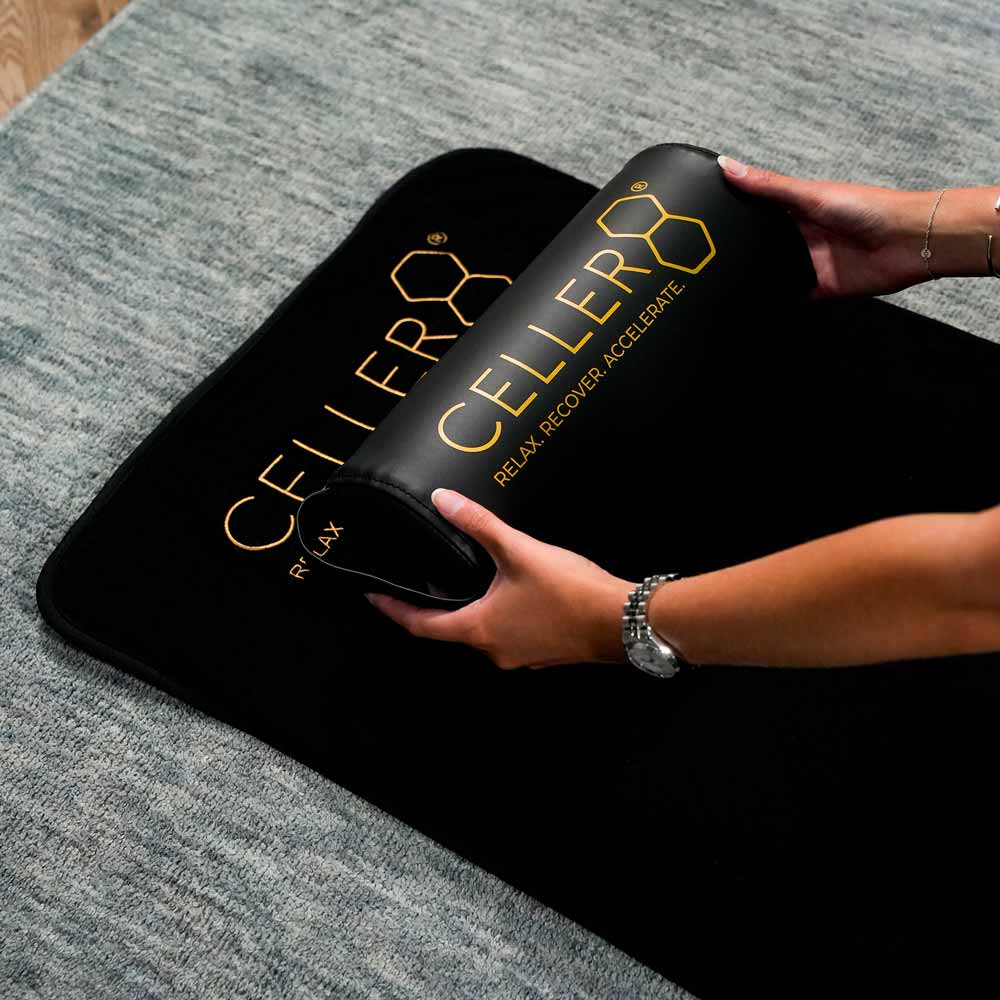 CELLER8 neck pillow being placed down on CELLER8 full body PEMF mat