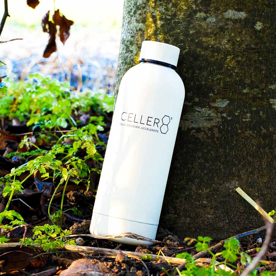Tan CELLER8 water bottle leant against tree 