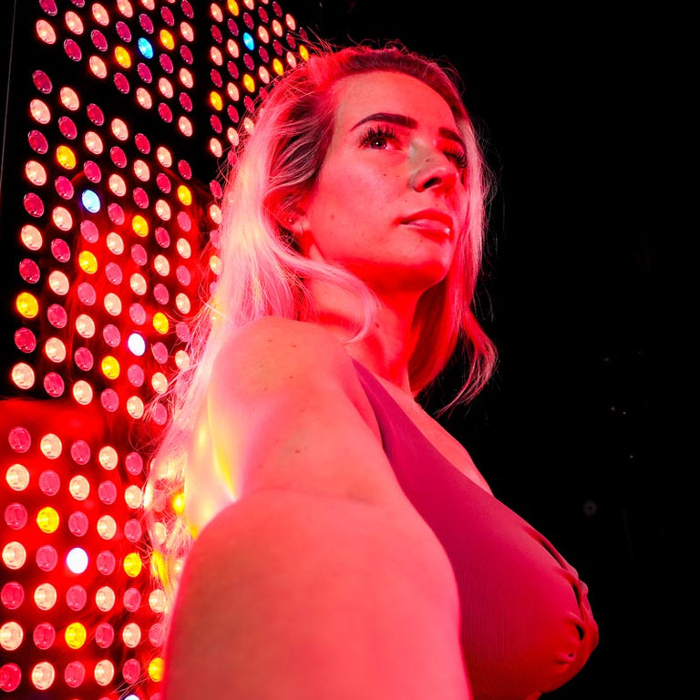 Women in front of red light panel 