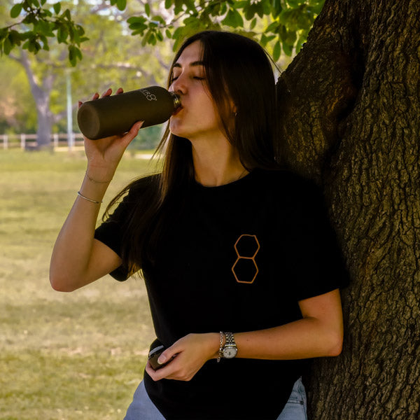 Women drinking from CELLER8 water bottle in a park wearing Biohacker Era  t-shirt 