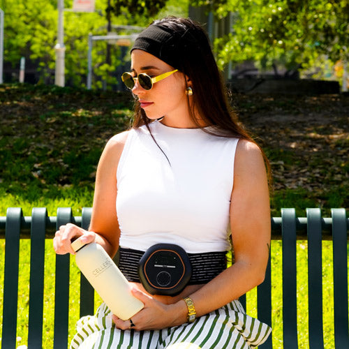 Women on bench in park wearing CELLER8 holding cream water bottle