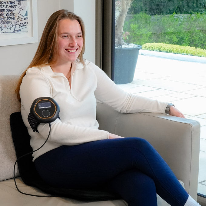Women sat on sofa using CELLER8 travel mat with CELLER8 around arm