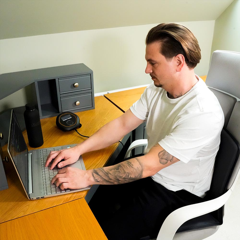 Man sat on travel mat working from home