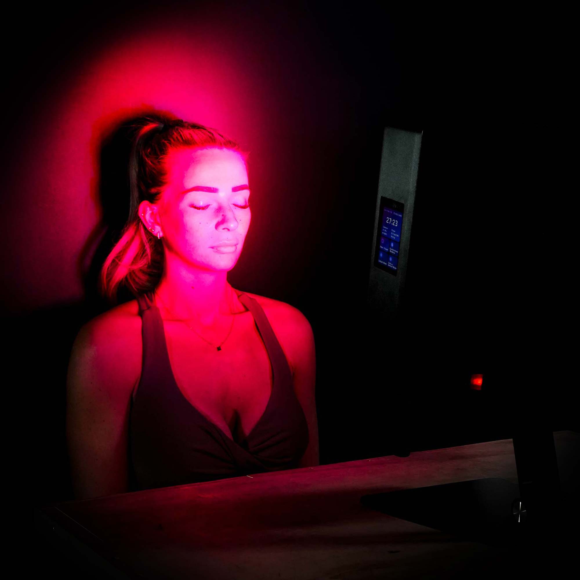 Women using CELLER8 Desktop red light panel on face