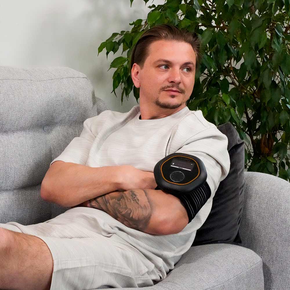 Wearing CELLER8 PEMF device on sofa on arm